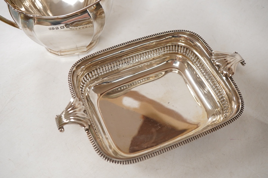 A George V silver two handled butter dish, by George Howson, Sheffield, 1928, 16.7cm over handles, together with a George V silver cream jug, by William Suckling Ltd, Birmingham, 1931, 10.7oz.